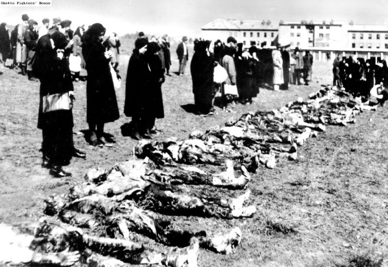Slovak women stand over the bodies of men shot by the Germans
